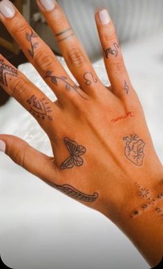 a woman's hand with many tattoos on it