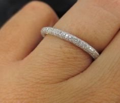 a woman's hand with a wedding band on it and a diamond ring in the middle