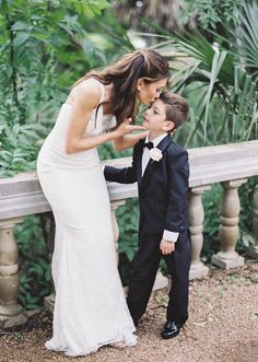 a woman in a white dress and a boy in a black suit