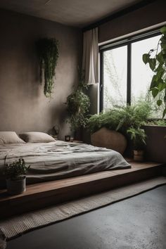 a bed sitting next to a window with plants on the wall and in front of it