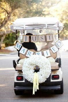 a golf cart decorated with a wreath and just married sign