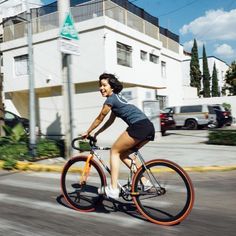 a woman is riding her bike down the street