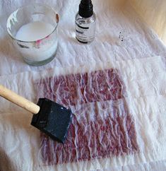 a table with some paint and a brush on it next to a bowl of water