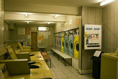 an empty laundry room with washers and dryers on the walls, in front of a sign that says soap shop