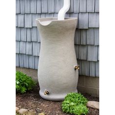 a large white vase sitting next to a house