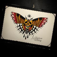 a skull and butterfly tattoo design on a card