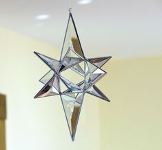 a glass star ornament hanging from the ceiling