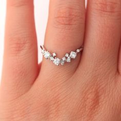 a woman's hand with a diamond ring on top of her finger, showing the middle