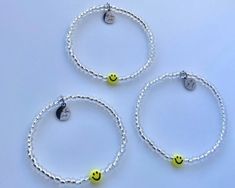 three bracelets with smiley faces on them