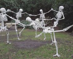 two skeleton statues are dancing in the grass