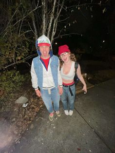 two people standing next to each other near a tree