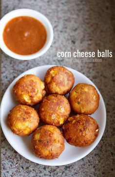 corn cheese balls on a plate with dipping sauce next to it and a small white bowl