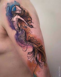 a woman's arm with a tattoo on it that has an image of a fish in the water