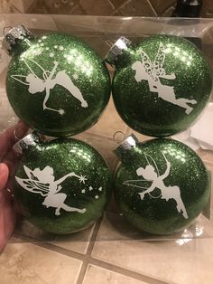 four green christmas ornaments with tinkerbells on them