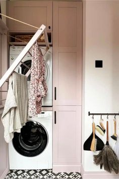 a washer and dryer in a small room with pink paint on the walls