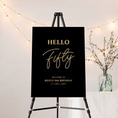 a black and gold sign with the words hello fifty written in cursive font