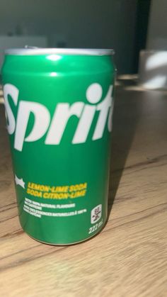 a can of sprite sitting on top of a wooden table