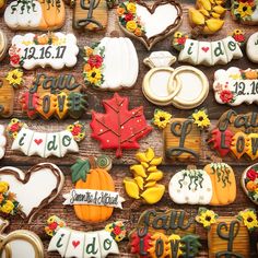 many decorated cookies are arranged on a wooden table with the names of each wedding and date