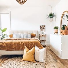 a bedroom with white walls and wooden floors