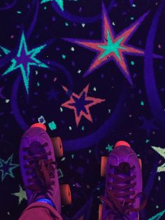 a pair of purple and green sneakers on top of skateboards in front of stars