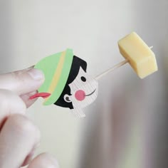 a hand holding a toothpick with a cartoon character on it