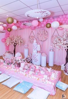 a table is set up with pink and white decorations