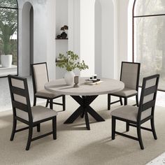 a round table with four chairs around it in a white and black dining room setting