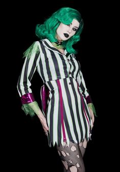 a woman with green hair and makeup is dressed up as beetlegy girl in black and white striped dress