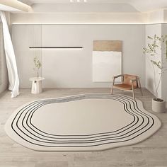 a large white rug in the middle of a room with chairs and potted plants