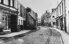 an old black and white photo of a cobblestone street