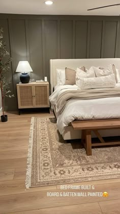 a large bed sitting on top of a hard wood floor next to a wooden table