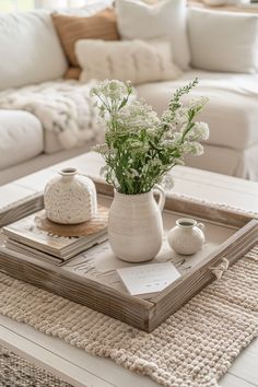 a white coffee table with flowers in a vase on it