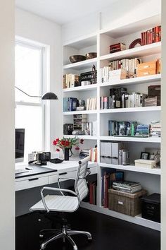 a home office with white bookcases and black flooring is pictured in this image