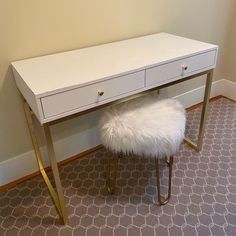 a white desk with two drawers and a fur stool in the corner next to it