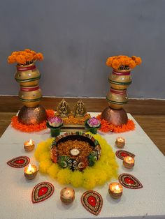 an arrangement of flowers and candles on a table