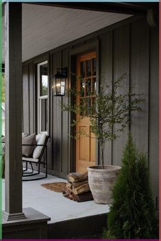 a porch with a chair and potted plant on the front step next to it