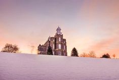 a large building sitting on top of a snow covered hill in the middle of winter