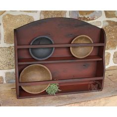 a wooden shelf with three bowls on it and a plant growing out of the top