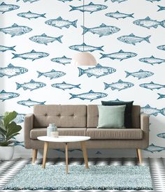 a living room with blue fish wallpaper and a beige couch in front of it