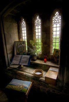 an old church with stained glass windows and a book on the table next to it