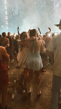 a group of people standing around each other in front of a crowd at a music festival