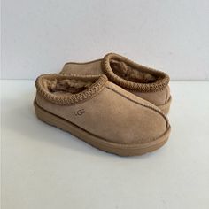 Product Specs: * Suede Upper. * Tasman Braid. * 10mm Uggplush 80% Upcycled Wool, 20% Lyocell Lining. * 10mm Uggplush 80% Upcycled Wool, 20% Lyocell Insole. * Treadlite By Ugg Outsole. * Textile Binding. * Eva Outsole. * Genuine Fleece Sock Liner For Comfort And Warmth. * Top-Of-The-Line Australian Winter Boots. * All My Ugg Are 100% Authentic, Brand New And Never Been Worn. ** The Inside Sizing Tag Is Marked To Avoid Store Returns. This However Did Not Effect The Look. Shd N Grg Lss Shearling Slippers With Rubber Sole And Closed Toe, Casual Closed Toe Shearling Slippers, Casual Shearling Closed Toe Slippers, Classic Beige Slippers With Round Toe, Classic Beige Round Toe Slippers, Classic Sheepskin Slippers With Round Toe, Ugg Sand, Australian Winter, Fleece Socks