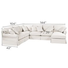 a white sectional couch with pillows and measurements