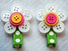 two plastic flower clips with white and pink buttons