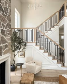 a living room filled with furniture and a fire place next to a stair case in front of a stone wall