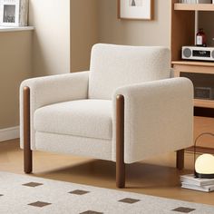 a white chair sitting in a living room next to a book shelf