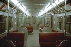 an empty subway car with red leather seats