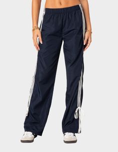 These Track Pants Offer Both Style And Comfort, Making Them Perfect For A Sporty Yet Fashionable Look. They're Ideal For Any Activity, Ensuring You Feel Comfortable And Confident Throughout Your Entire Day. Track Pants. Side Stripe Detailing. Ribbon Tie Ankle Detail. Elastic Waist. 100% Polyester. Item Care: Wash With Similar Colors. Model Wears Size S. Model Height Is 5'8. | Edikted Remy Ribbon Track Pants 80s Y2k, Pants Jogger, Track Pants Women, Pants Details, Low Rise Jeans, Leather Mini Skirts, Jogger Sweatpants, Knit Pants, Side Stripe