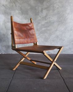 a brown leather chair sitting on top of a cement floor