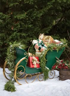 a sleigh filled with presents in the snow next to evergreens and pine cones